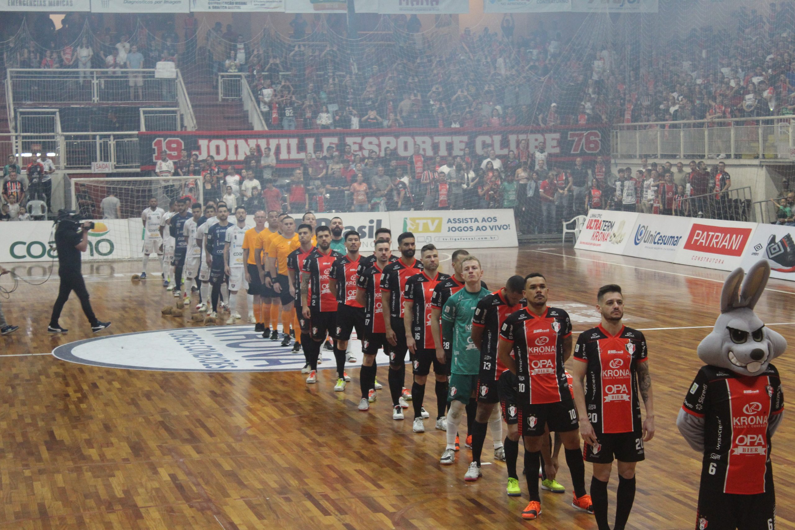 Jogadores do JEC e do Campo Mourão alinhados dentro de quadra para o hino nacional.