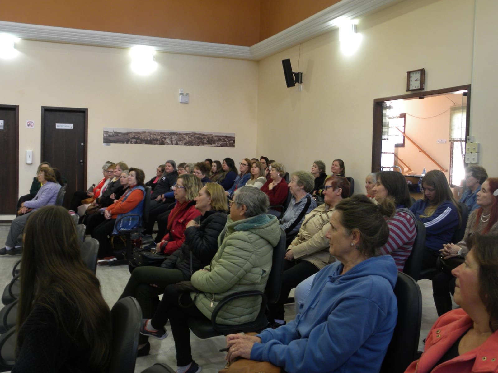 Pessoas sentadas em reunião.