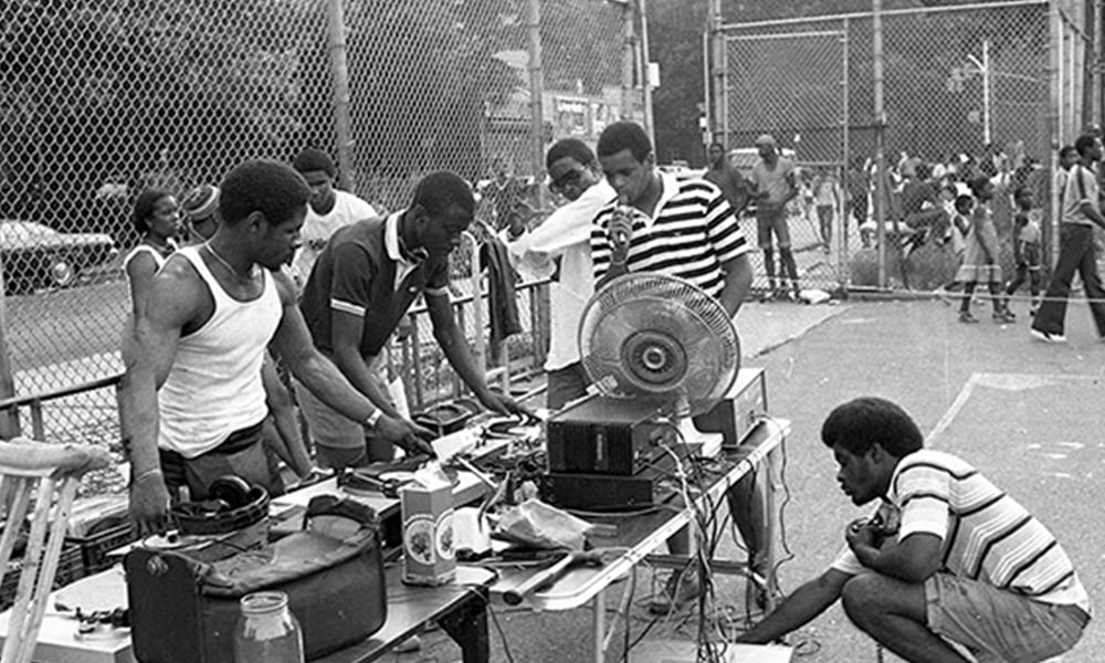 Pessoas em uma festa de Hip-Hop no Bronx, em Nova York. A imagem está em preto e branco.